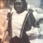 A member of the University of Arkansas at Pine Bluff (UAPB) Marching Band wears a flag line uniform (1998) made by Dorothy J. J. Anderson.