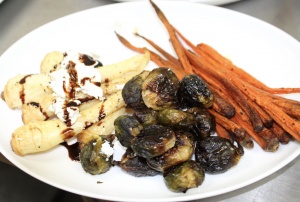 The third course is added to platters. Brussel sprouts and other veggies. See Front Porch Hospitality Group - Chef’s inaugural dinner menu. Credit: Charity Stephens