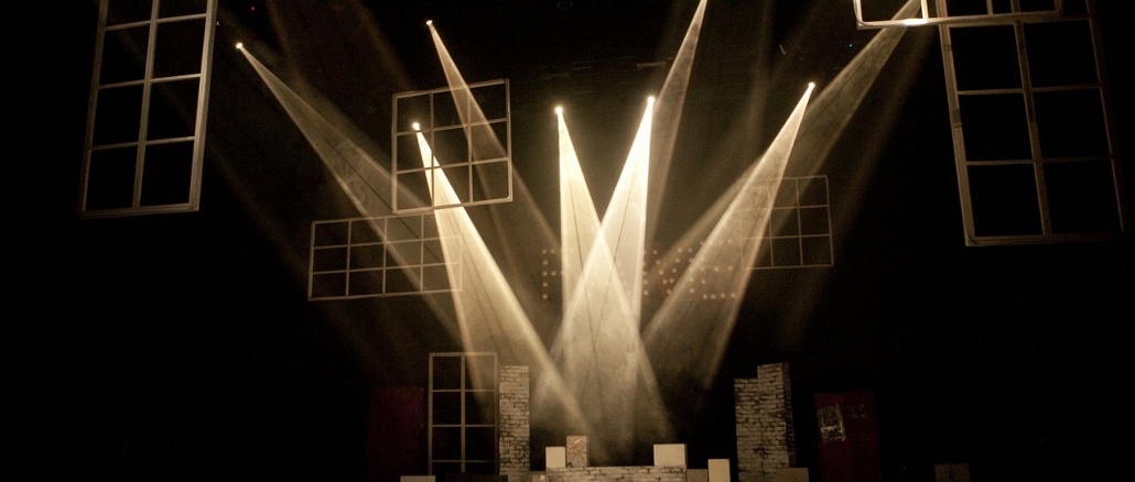 Image of lights on a stage form pattern suggestive of a crown. Community events include the King Cotton Classic basketball tournament and a youth theatre workshop.