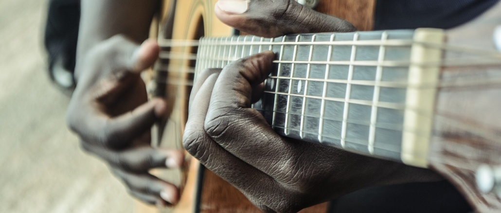 Guitar, Acoustic, and Hands Image showing close-up of acoustic guitar played by hands of African-American man. Represents Acrican-Americans, lack history, and/or music. Credit: sycline/Pixabay
